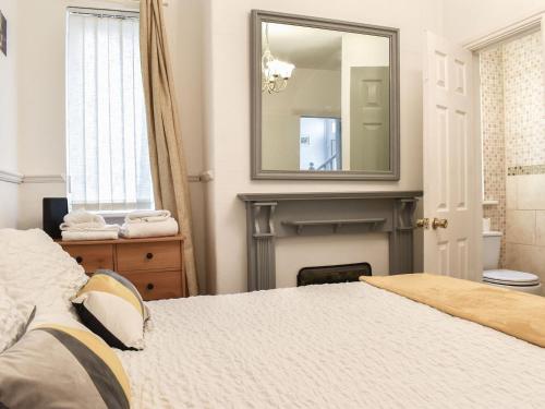 a bedroom with a bed with a fireplace and a mirror at Huddersfield House, Wood View in Huddersfield