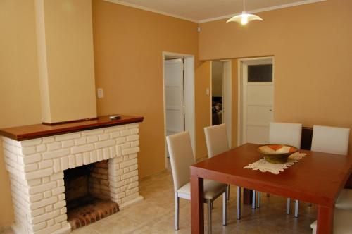 a dining room with a table and a fireplace at Siete Cepas in San Rafael