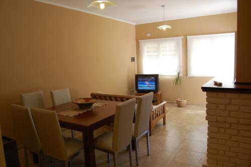 a dining room with a table and chairs and a television at Siete Cepas in San Rafael