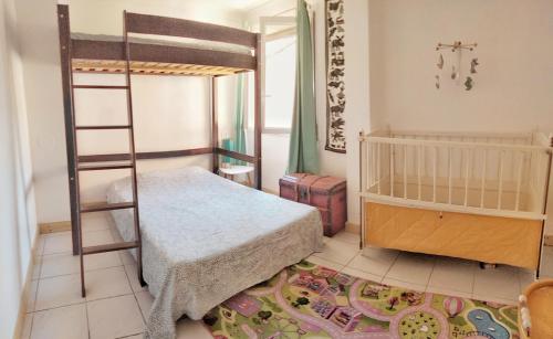 une chambre avec un lit superposé et une échelle dans l'établissement Appart coeur de village - proche des criques, à Port-Vendres