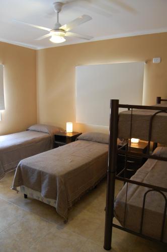 a bedroom with two beds and a ceiling fan at Siete Cepas in San Rafael