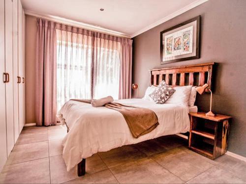 a bedroom with a large bed and a window at The Russel Guest House in Port Elizabeth