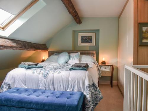 a bedroom with a bed with a blue bench in it at Yew Tree Cottage in Old Brampton