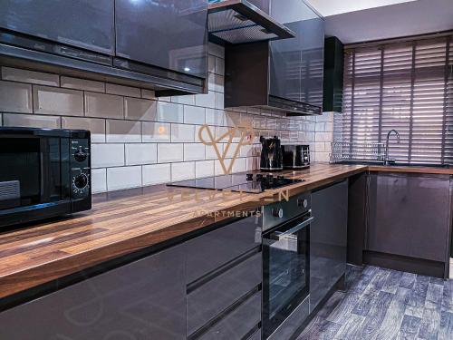 a kitchen with stainless steel appliances and a microwave at Velveteen by The V Group in Blackpool