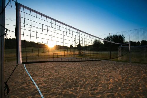 a volleyball net with the sun setting behind it at Highland Warmia - Gospodarstwo agroturystyczne in Jeziorany