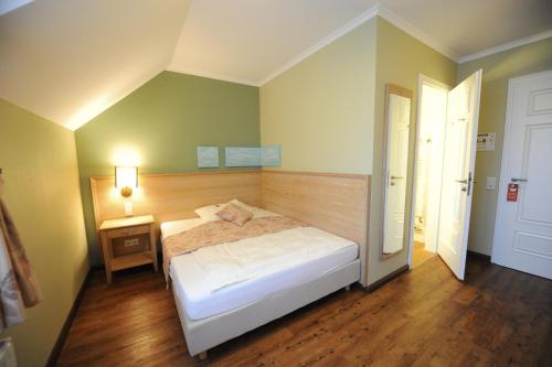a bedroom with a bed and a wooden floor at Dreimädelhaus - Kirchseelte in Kirchseelte