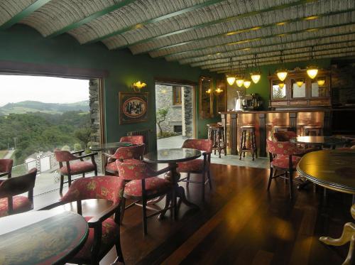 a restaurant with tables and chairs and a view at Casona El Gurugu in Luarca