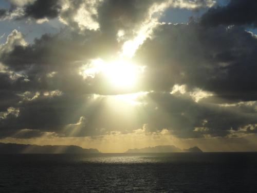 a sun shining through the clouds over the water at Apartment Palma Madeira wandern und tauchen in Caniço
