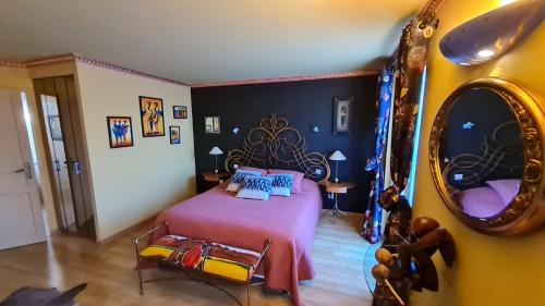 Schlafzimmer mit einem Bett und einem Spiegel in der Unterkunft La casa color in Lamagdelame
