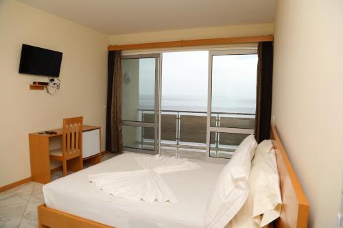 ein Schlafzimmer mit einem Bett und einem großen Fenster in der Unterkunft Cruzeiro Guest House in São Filipe