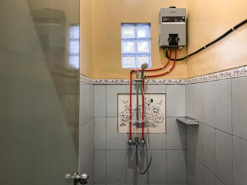 a shower in a bathroom with a window at Unique Homestay 443 in Yogyakarta