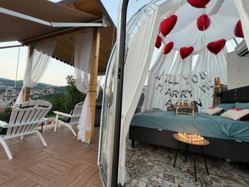 Un dormitorio con una cama con corazones rojos. en Cupola glamping dome Sarajevo en Sarajevo