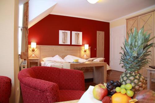 Habitación de hotel con cama y mesa con fruta en Dreimädelhaus - Kirchseelte, en Kirchseelte