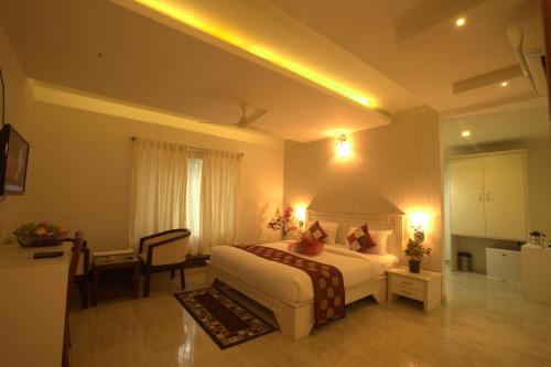 a hotel room with a bed and a desk and a kitchen at Royal shades kodihali in Bangalore