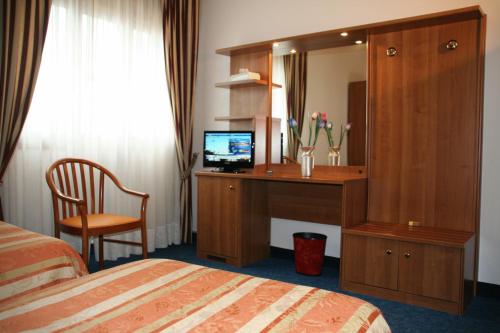 a hotel room with a desk and a mirror at Hotel Kristall in San Donà di Piave