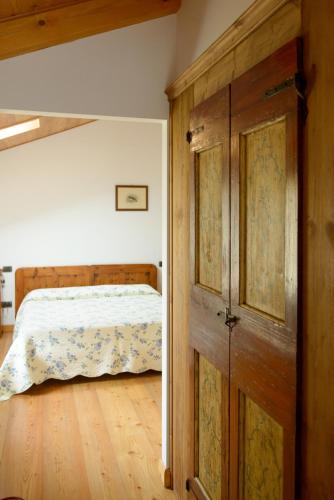 a bedroom with a bed and a wooden door at Ca' Premuda Locazione Turistica in Codognè