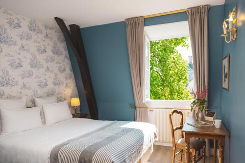 a bedroom with a bed and a window at Hotel des Grandes Ecoles in Paris