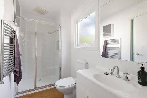 a white bathroom with a toilet and a shower at Beach Side in Aireys Inlet