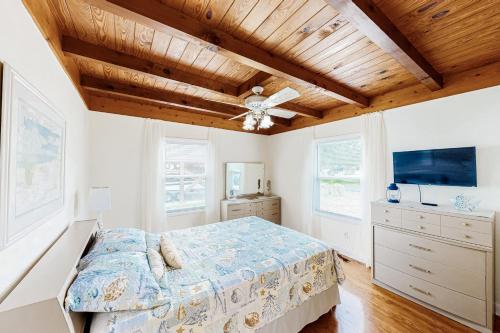 a bedroom with a bed and a wooden ceiling at Ginny's Coastal Cottage in Oak Island