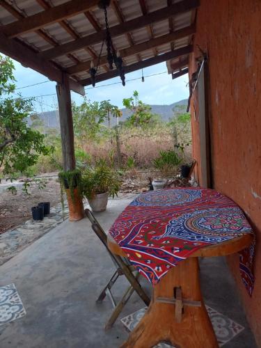 a table and a chair on a porch at Casa Kali - O seu refúgio nas montanhas! in Sao Jorge