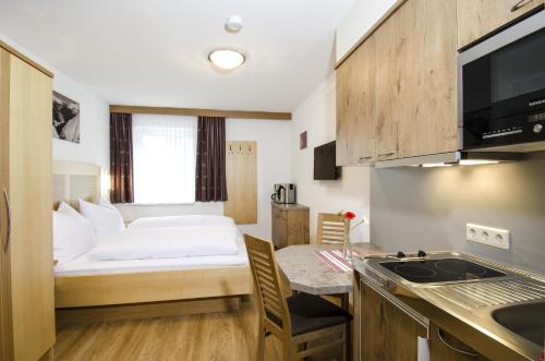 a small room with a bed and a kitchen at Apart Maurice in Galtür