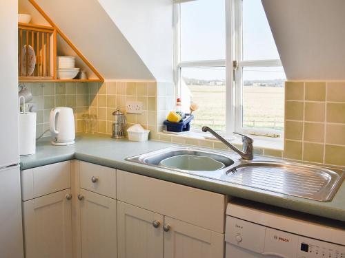 eine Küche mit einem Waschbecken und einem Fenster in der Unterkunft The Stables in Bealings