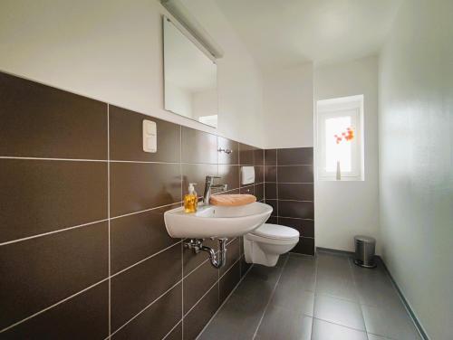 ein Bad mit einem Waschbecken und einem WC in der Unterkunft Ferienwohnungen MAXIMA in Bad Arolsen