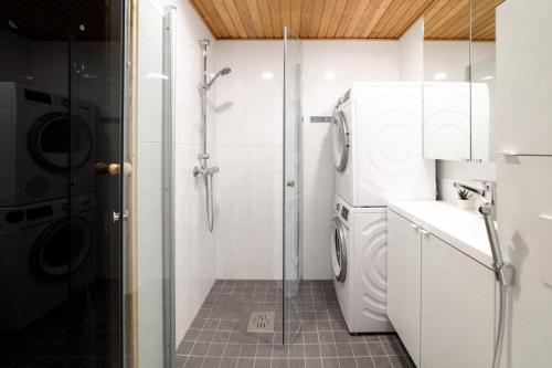 ein Bad mit einer Dusche, einer Waschmaschine und einem Trockner in der Unterkunft ULEABO Neat 48 m2 two-room flat with sauna in Oulu