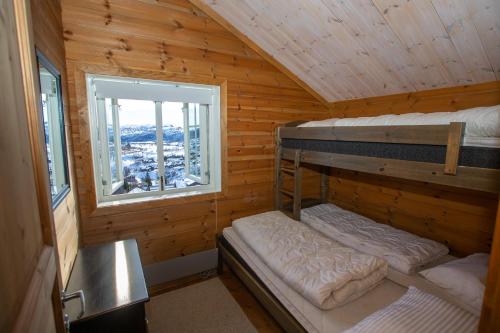 two bunk beds in a wooden cabin with a window at Sirdal Mountain Lodge, ski in-out in Sinnes