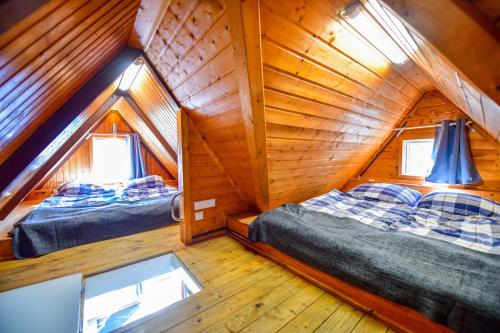 a bedroom with two beds in a wooden cabin at Nordic Ferienpark Sorpesee in Sundern