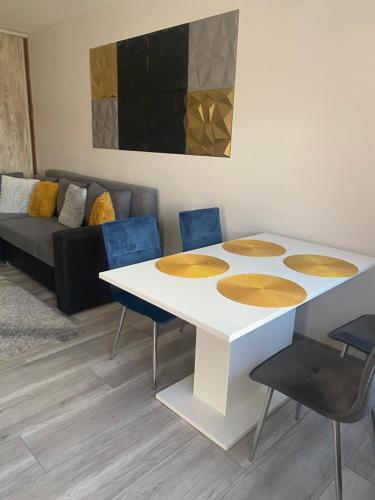 a table and chairs in a living room with a couch at Gabrielle apartman in Hajdúszoboszló