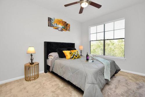 a bedroom with a bed and a ceiling fan at The Turquoise Suite in Houston