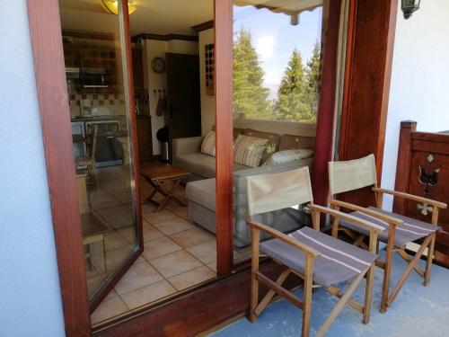 une chambre avec deux chaises et un miroir dans l'établissement Pied des pistes, balcon, 6 pers, parking, animaux admis - FR-1-557-121, à Les Adrets