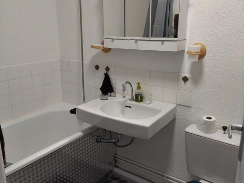 une salle de bain blanche avec un lavabo et une baignoire dans l'établissement Appartement 2 pièces confortable, au pied des pistes, proche commerces, avec balcon et équipements modernes - FR-1-557-124, à Les Adrets