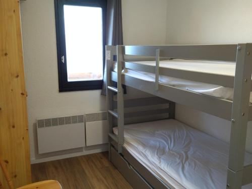 une chambre avec deux lits superposés et une fenêtre dans l'établissement Appartement 2 pièces confortable, au pied des pistes, proche commerces, avec balcon et équipements modernes - FR-1-557-124, à Les Adrets