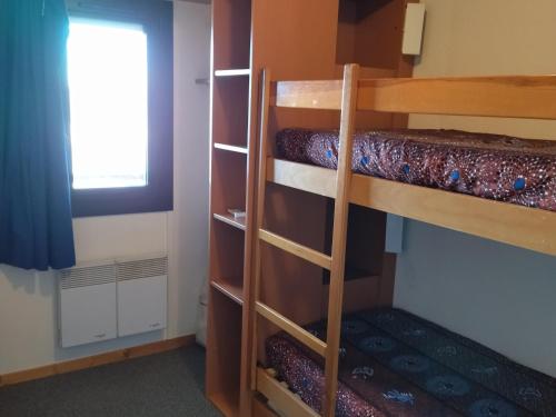 une chambre avec deux lits superposés et une fenêtre dans l'établissement Appartement cosy 5 pers au pied des pistes avec balcon et équipements pratiques - FR-1-557-126, à Les Adrets