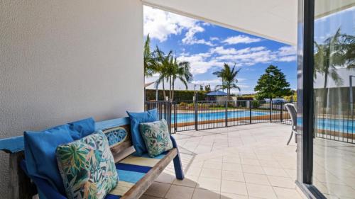 a patio with a bench and a swimming pool at 108 The Boathouse in Tea Gardens