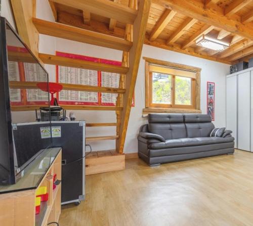 a living room with a couch and a television at Saranbang Pension in Gapyeong