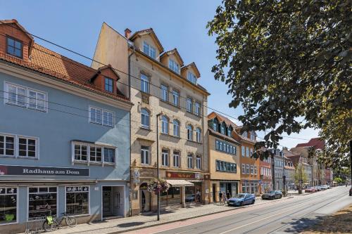 een straat in een stad met gebouwen en auto's bij Hotel Garni " Am Domplatz" in Erfurt