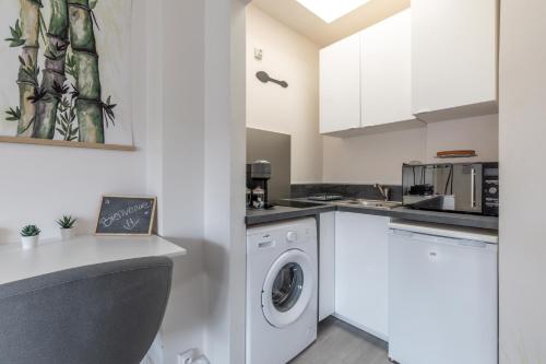 讓蒂伊的住宿－Esprit Tropical，白色的厨房配有洗衣机和烘干机