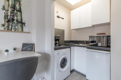 a white kitchen with a washer and dryer at Esprit Tropical in Gentilly