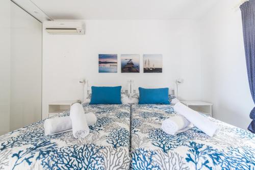 Schlafzimmer mit einem großen Bett mit blauer und weißer Bettwäsche in der Unterkunft Home2Book Stunning Apartment Rocas Rojas in San Bartolomé de Tirajana