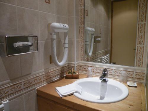 La salle de bains est pourvue d'un lavabo et d'un miroir. dans l'établissement Le Caprice Des Neiges, à Crest-Voland
