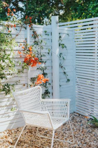 a white chair sitting in front of a fence at Senhora do Cabo Meco Homy Holidays in Sesimbra