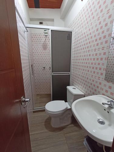 a bathroom with a toilet and a sink at Hotel Malaki in San Agustín