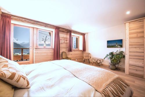 una camera da letto con un letto grande e una grande finestra di La Ferme des Fingères a Cordon