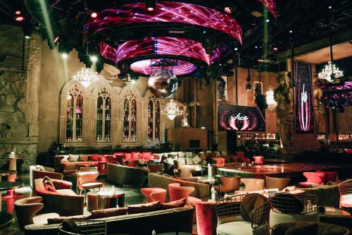 a restaurant with red lighting and tables and chairs at Ramee Dream Hotel Downtown in Dubai