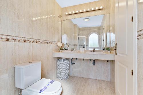 La salle de bains est pourvue de toilettes, d'un lavabo et d'un miroir. dans l'établissement Maison Arlette, à Mijas