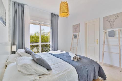 a bedroom with a bed with pillows and a window at Maison Arlette in Mijas Costa