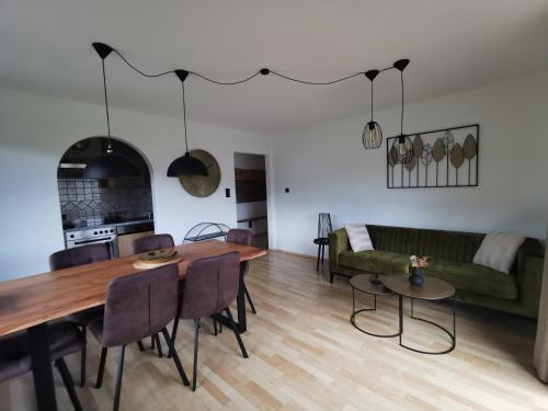 comedor y sala de estar con mesa y sillas en Ferienwohnungen Kienesberger, en Tiefgraben